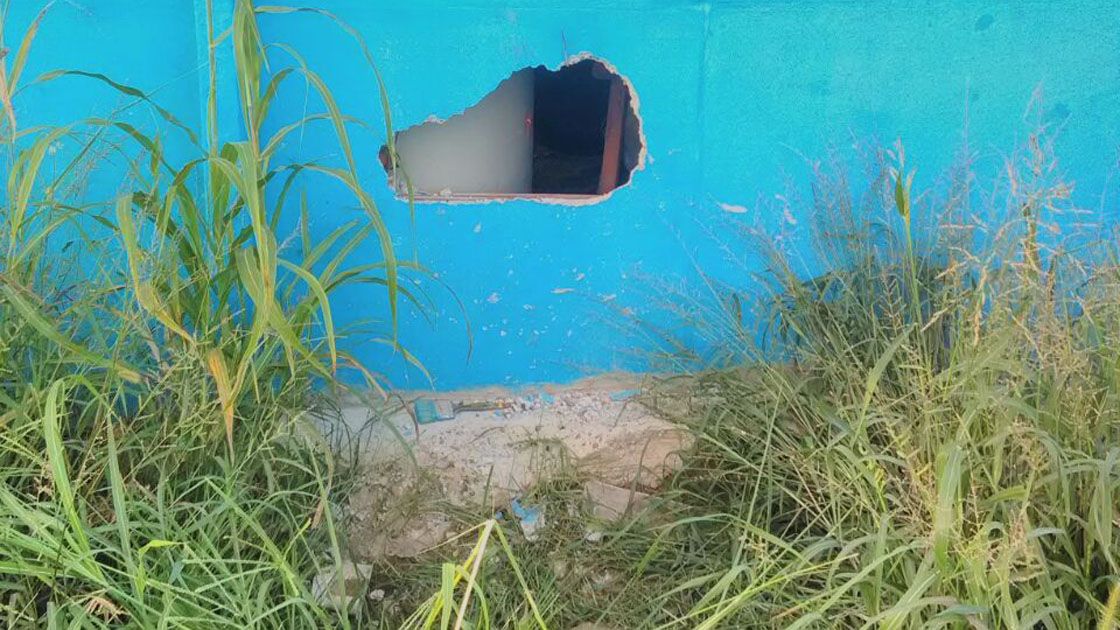 Con tiempo. Los delincuentes aprovecharon el terreno baldío de atrás para romper la pared.
