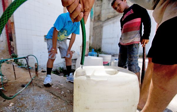 Paciencia. Habitantes del barrio popular La Dolorita, de Caracas, se abastecen de agua en una canilla.