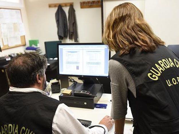 Dos guardias civiles investigan los ordenadores de pornografía infantil.
