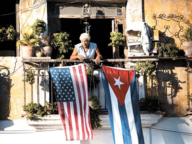 Apertura. Un cubano destaca las banderas de EE.UU. y su país.