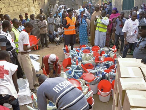 Un grupo de desplazados por Boko Haram recibe víveres de la Cruz Roja en Kano.