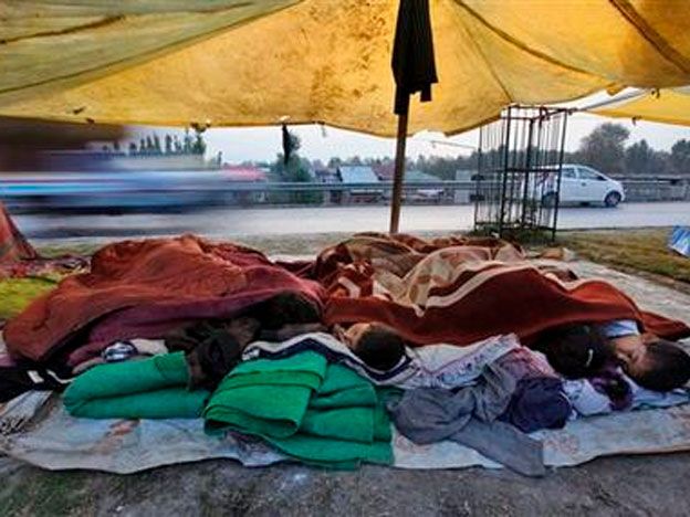 En esta imagen del 1 de octubre de 2014, jóvenes vícitmas de las recientes inundaciones en la Cachemira india duermen en una tienda improvisada a las afueras de Srinagar, en India. (AP Foto/Dar Yasin)