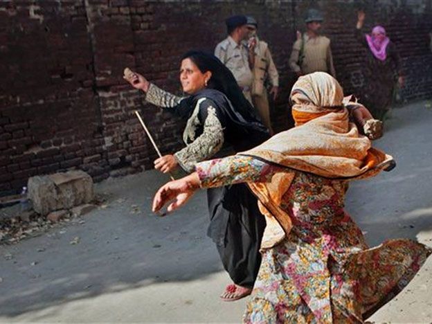 En esta imagen del 1 de octubre de 2014, manifestantes musulmanas anti indias lanzan piedras y ladrillos a la policía en Srinagar, India. Las inundaciones en esta conflictiva región del Himalaya mataron a 281 personas, destruyeron al menos 100.000 hogares y causaron unos 17.000 millones de dólares en daños. (AP Foto/Dar Yasin)