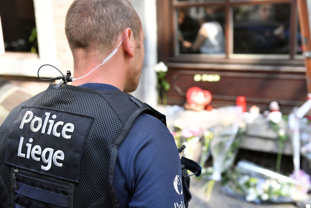 Un policía de Lieja desconsolado frente al santuario que se armó en el lugar donde murieron dos de sus compañeros. Foto: AP.