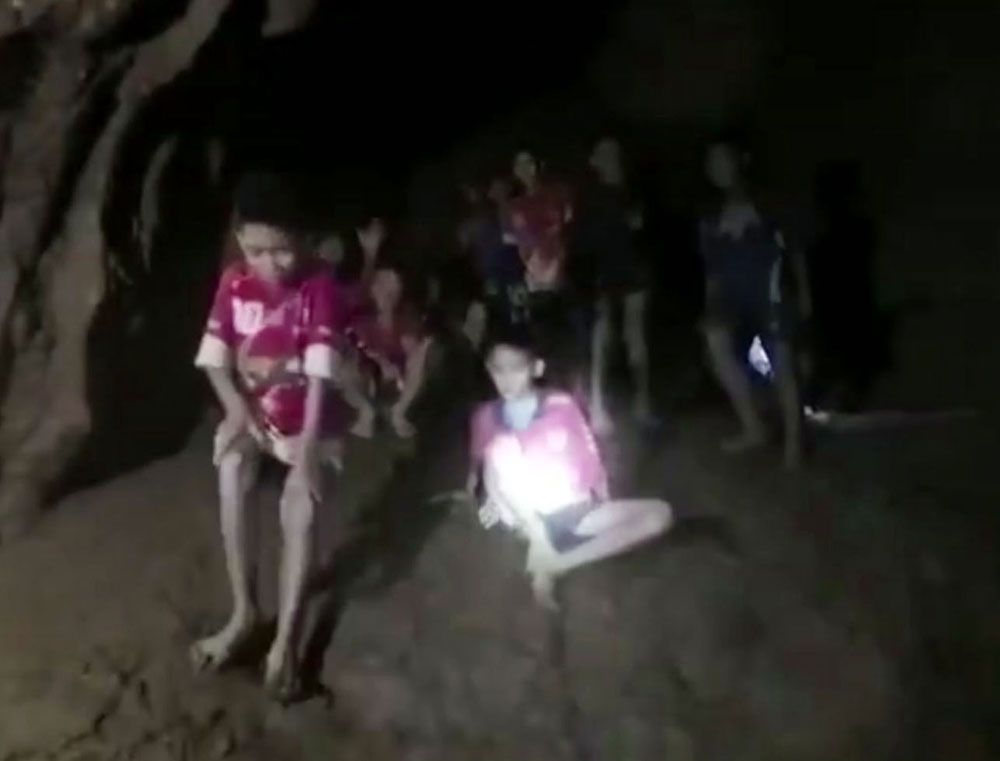 Los chicos en su ropa deportiva, sentados en una zona seca en la cueva