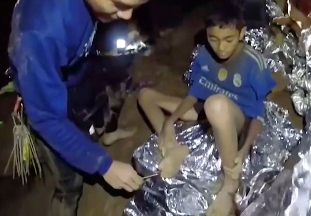 Socorrista. Uno de los niños es examinado por un médico militar tailandés. Socorrista. Uno de los niños es examinado por un médico militar tailandés.
