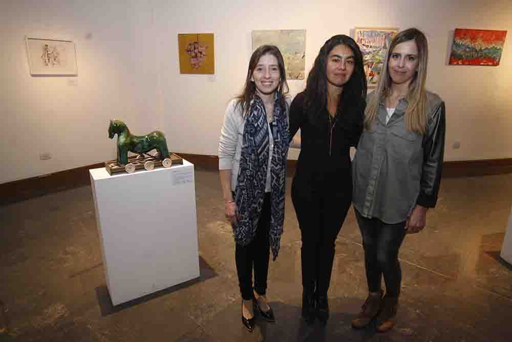 Cecilia Graña, Lorena Troncoso y Anabel Bermejo (Banco de Alimentos) junto a la obra Lo que no mostramos de cada uno, de Vivian Mayne.