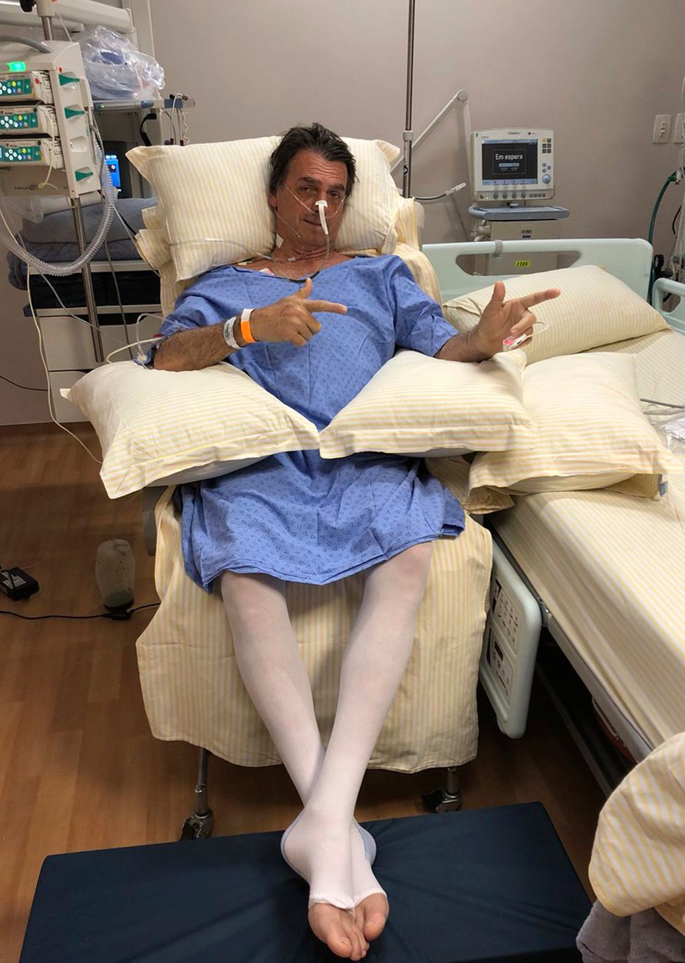 Bolsonaro aparece en una camilla, imitando dos armas con las manos. Foto: AP.