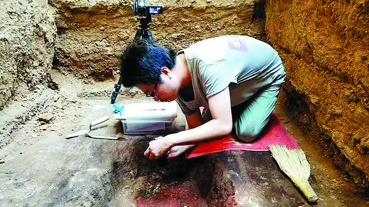 Un arqueólogo fotografía el proceso de excavación en el sitio de Jiuwutou en Yuncheng