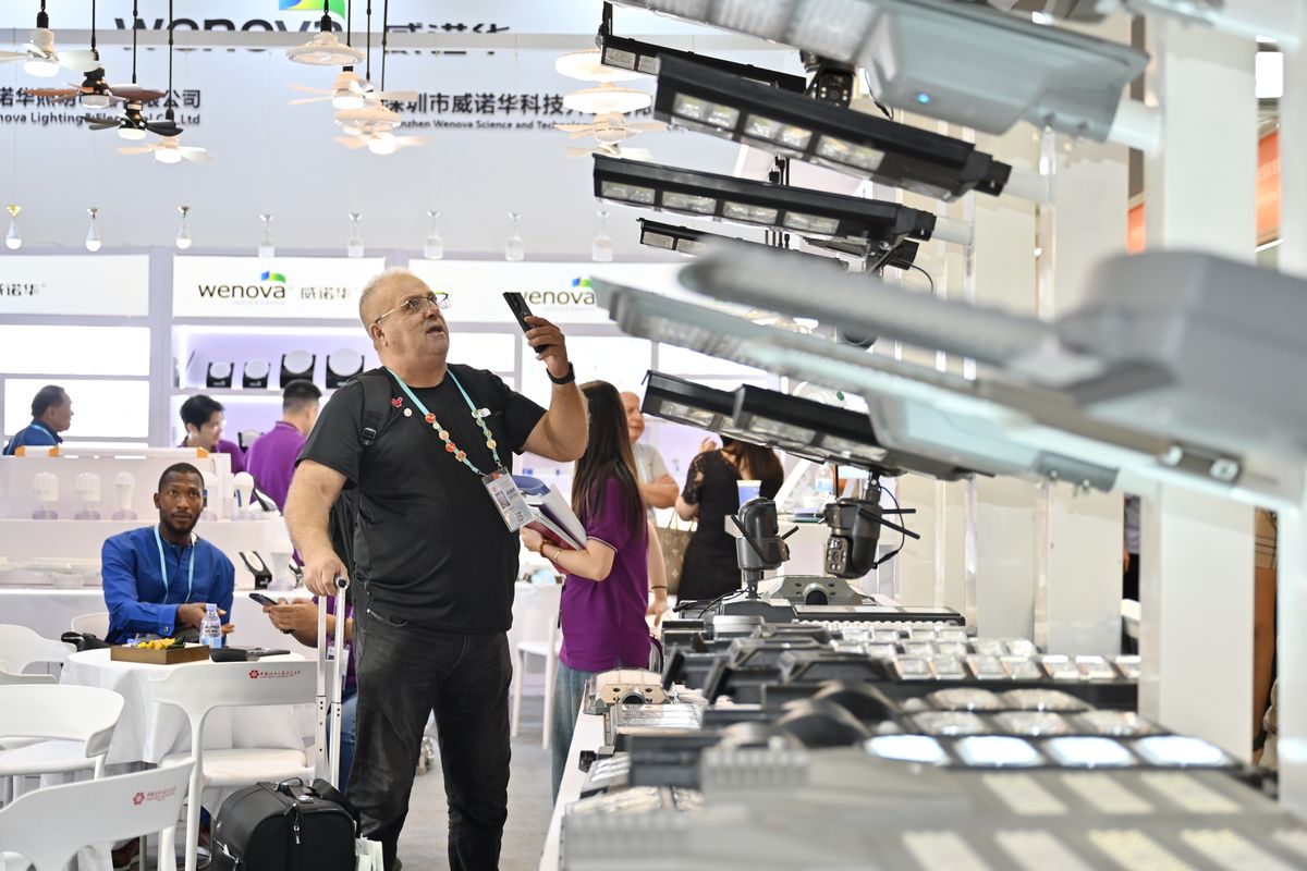 Un comprador extranjero toma fotografías de lámparas solares durante la 138ª edición de la Feria de Importación y Exportación de China, celebrada en Guangzhou, provincia de Guangdong, el 16 de octubre. CHEN CHUHONG / SERVICIO DE NOTICIAS DE CHINA.