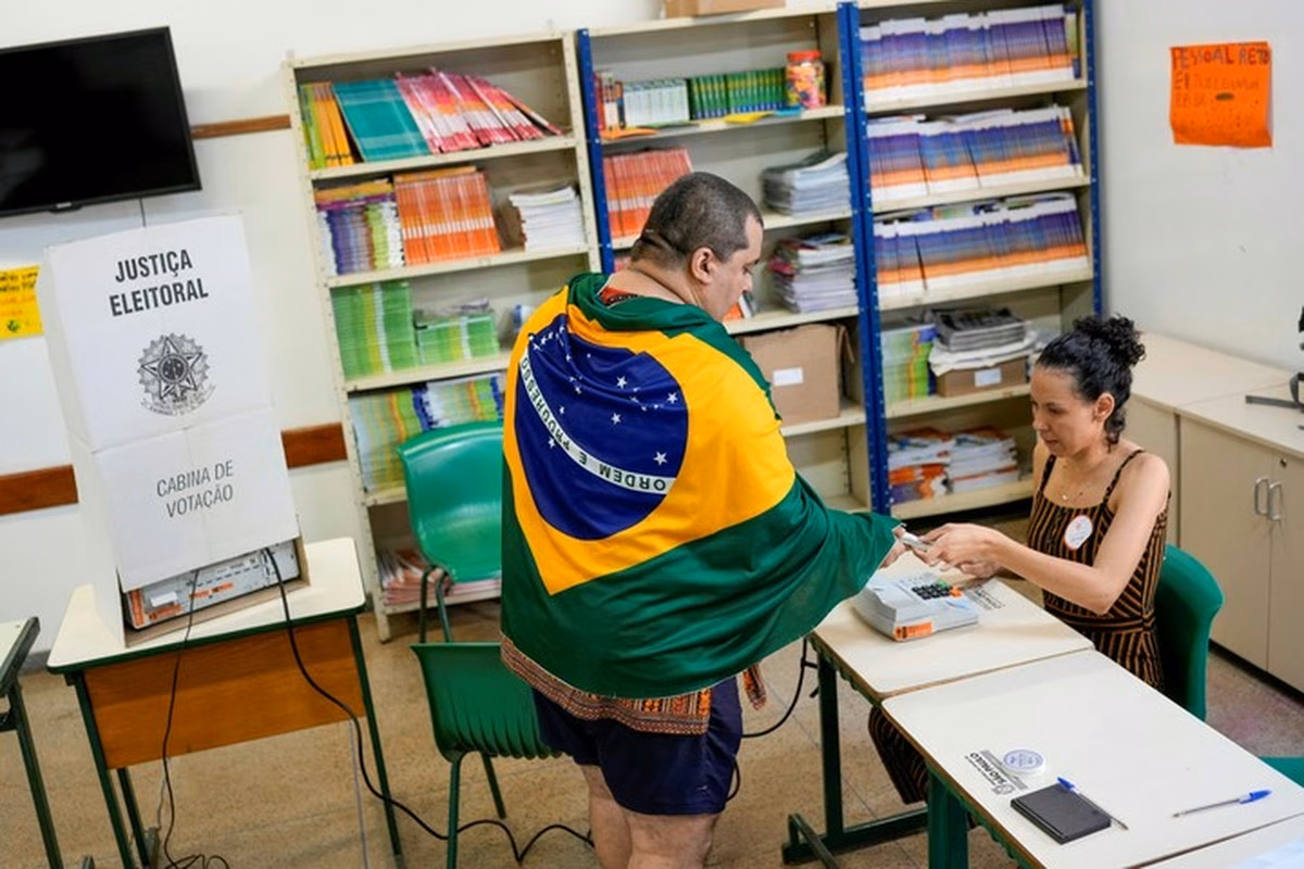 Un elector emite su voto para la fórmula presidencial en la urna electrónica oficial dispuesta en las mesas consulares. Un elector emite su voto para la fórmula presidencial en la urna electrónica oficial dispuesta en las mesas consulares.
