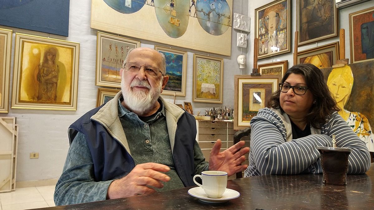 Padre e hija, con un fondo decorado por sus obras.