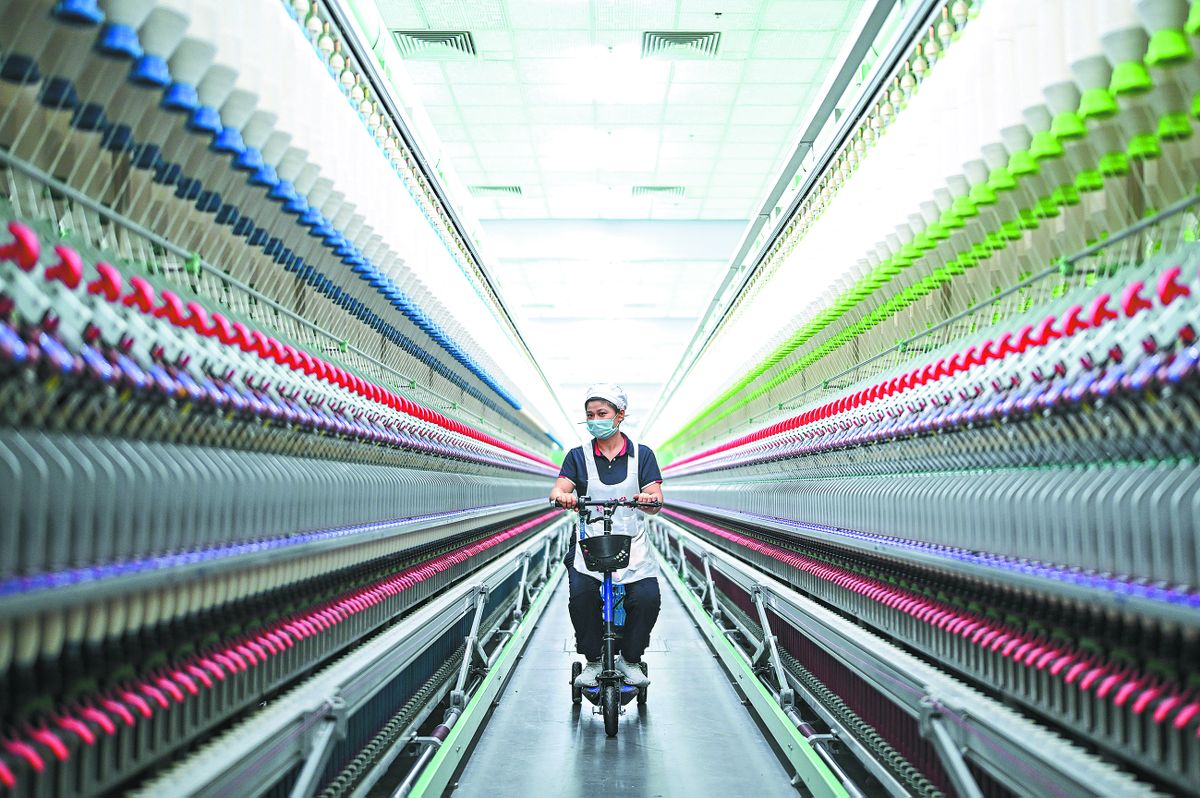 Una empleada inspecciona equipos textiles en una fábrica faro de Yancheng, provincia de Jiangsu. CHEN YEHUA / XINHUA.
