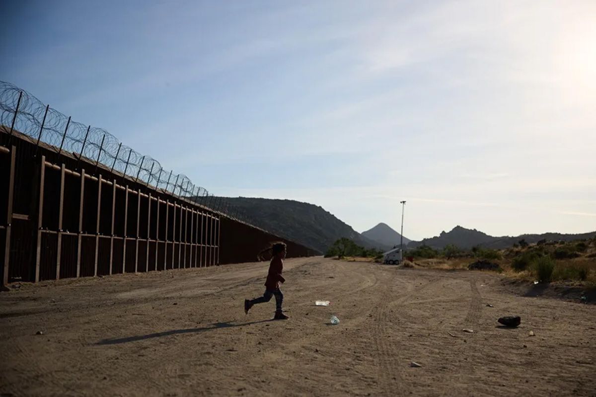 Un niño junto al muro fronterizo mientras espera a la Patrulla Fronteriza de Estados Unidos tras cruzar la frontera entre Estados Unidos y México con otros migrantes, en Jacumba, California, Estados Unidos (Archivo). Crédito: EFE/EPA/ALLISON DINNER.