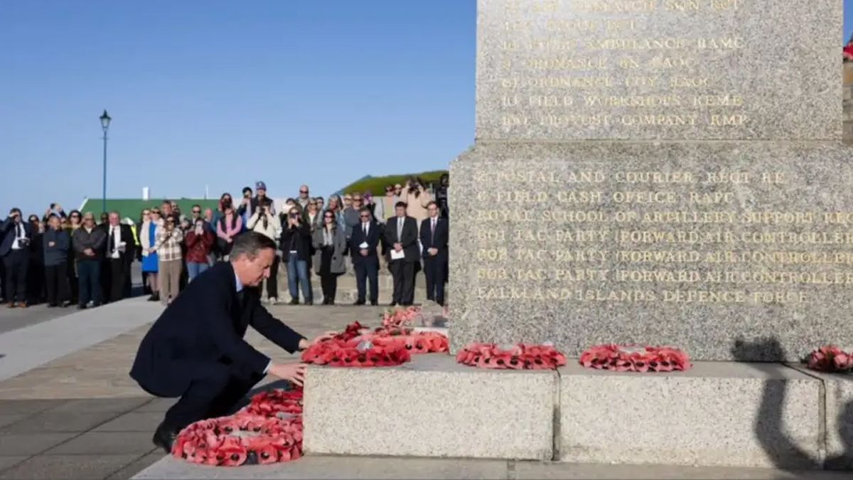 Cameron en Malvinas, frente a un monumento a caídos en la guerra.