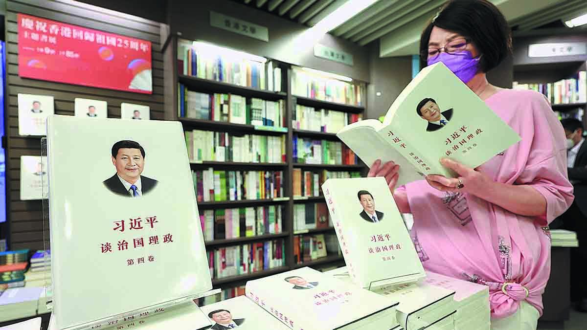 Una mujer lee una copia del cuarto volumen de Xi Jinping: La gobernanza de China en una librería en Hong Kong. EDMOND TANG / CHINA DAILY