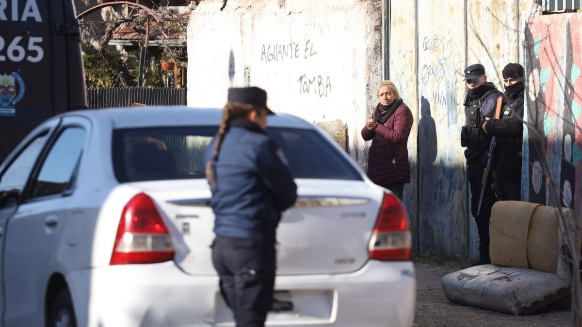 Una de las mujeres detenidas y algunos efectivos policiales. La foto se tomó este viernes en el predio que perteneció a Nicolás Gil Pereg. Una de las mujeres detenidas y algunos efectivos policiales. La foto se tomó este viernes en el predio que perteneció a Nicolás Gil Pereg.