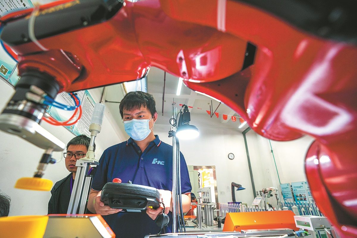 Dos docentes de escuelas técnicas se entrenan en la compañía Wuhan Huazhong Numerical Control para aprender sobre robots industriales de última generación