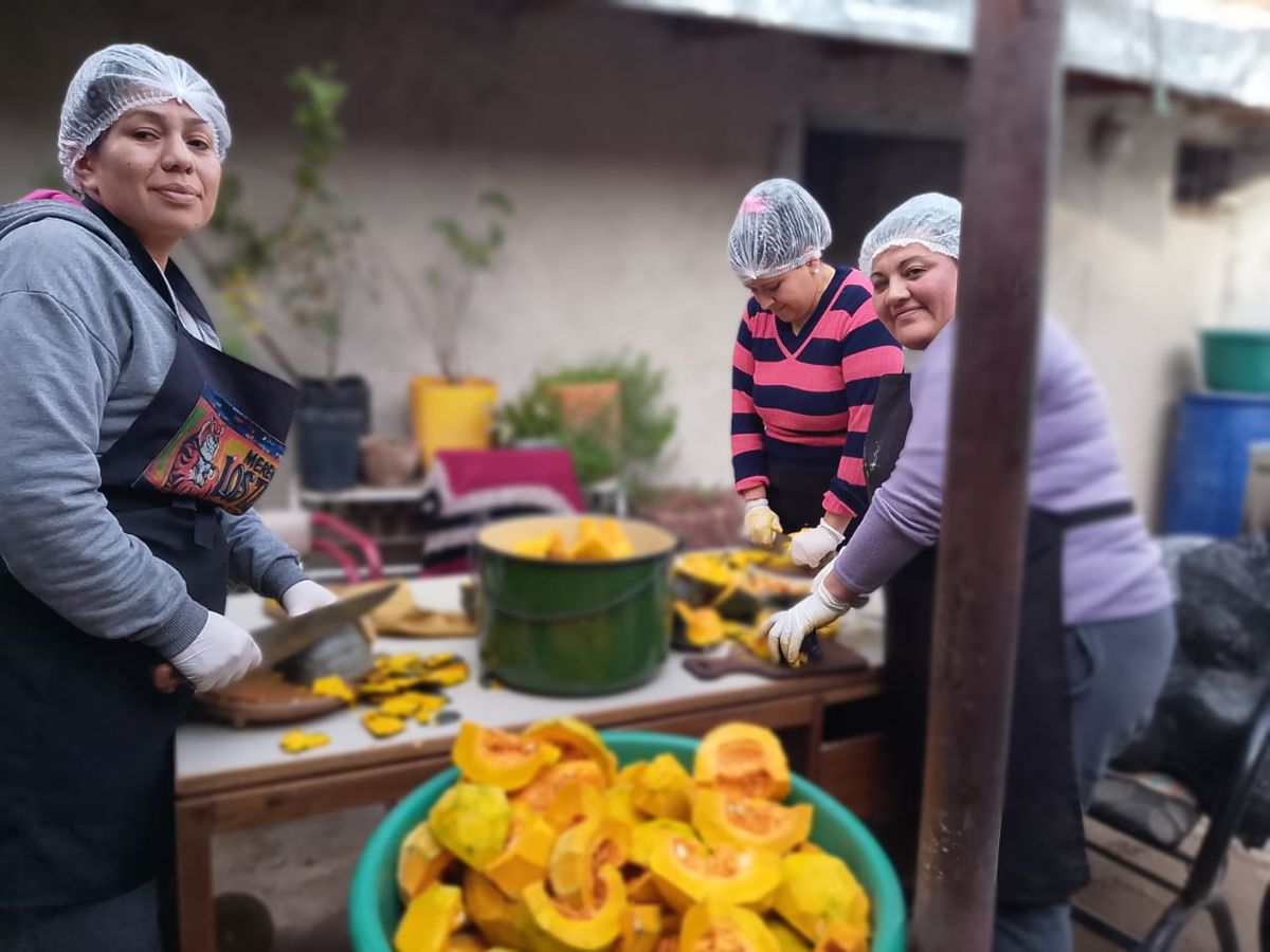 Tres de las voluntarias de Los Tigres, cortando el zapallo para el locro. Tres de las voluntarias de Los Tigres, cortando el zapallo para el locro.