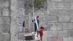 Dos niños levantaron un mástil en el patio de su casa e izan la bandera a diario