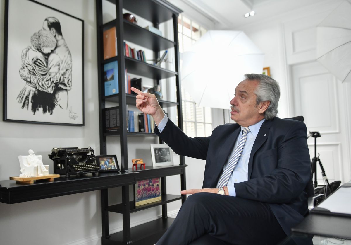 Referencia. Alberto Fernnández señala el cuadro de Perón y Evita.