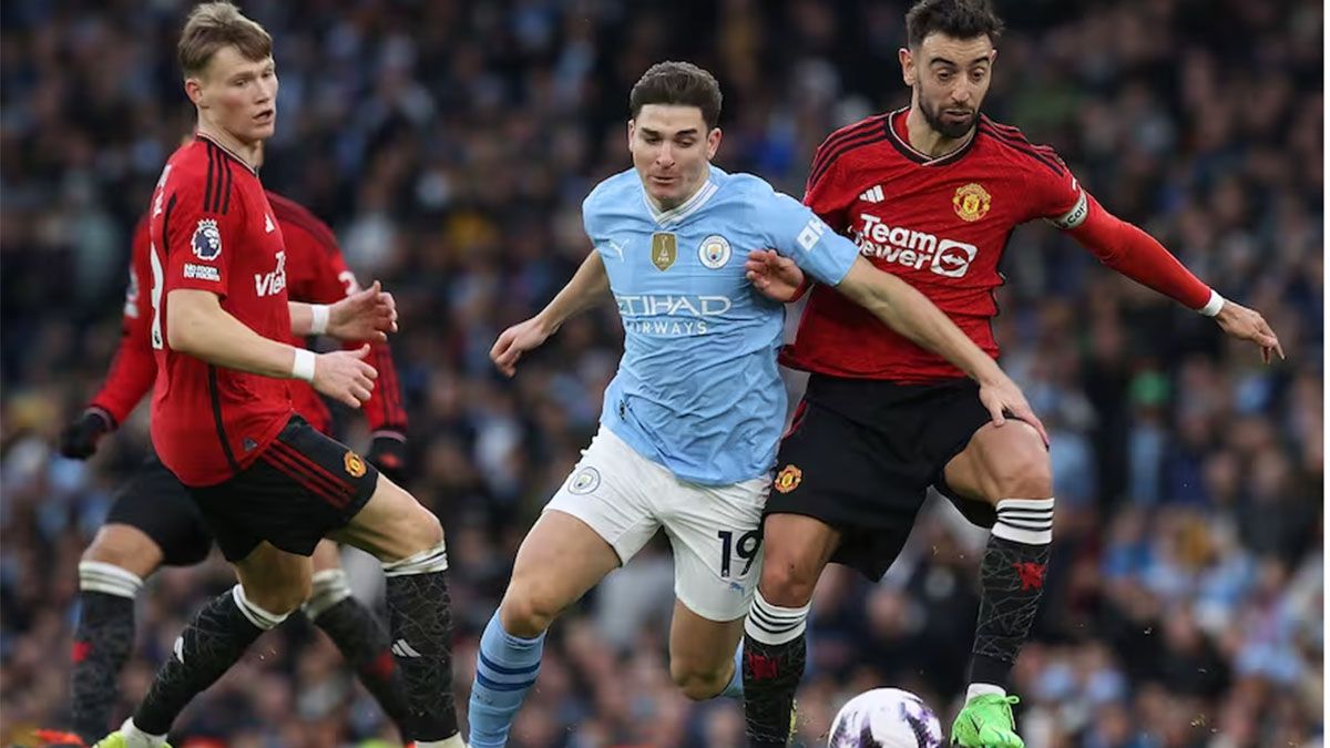 Julián Álvarez maniobra entre dos rivales del Manchester United.