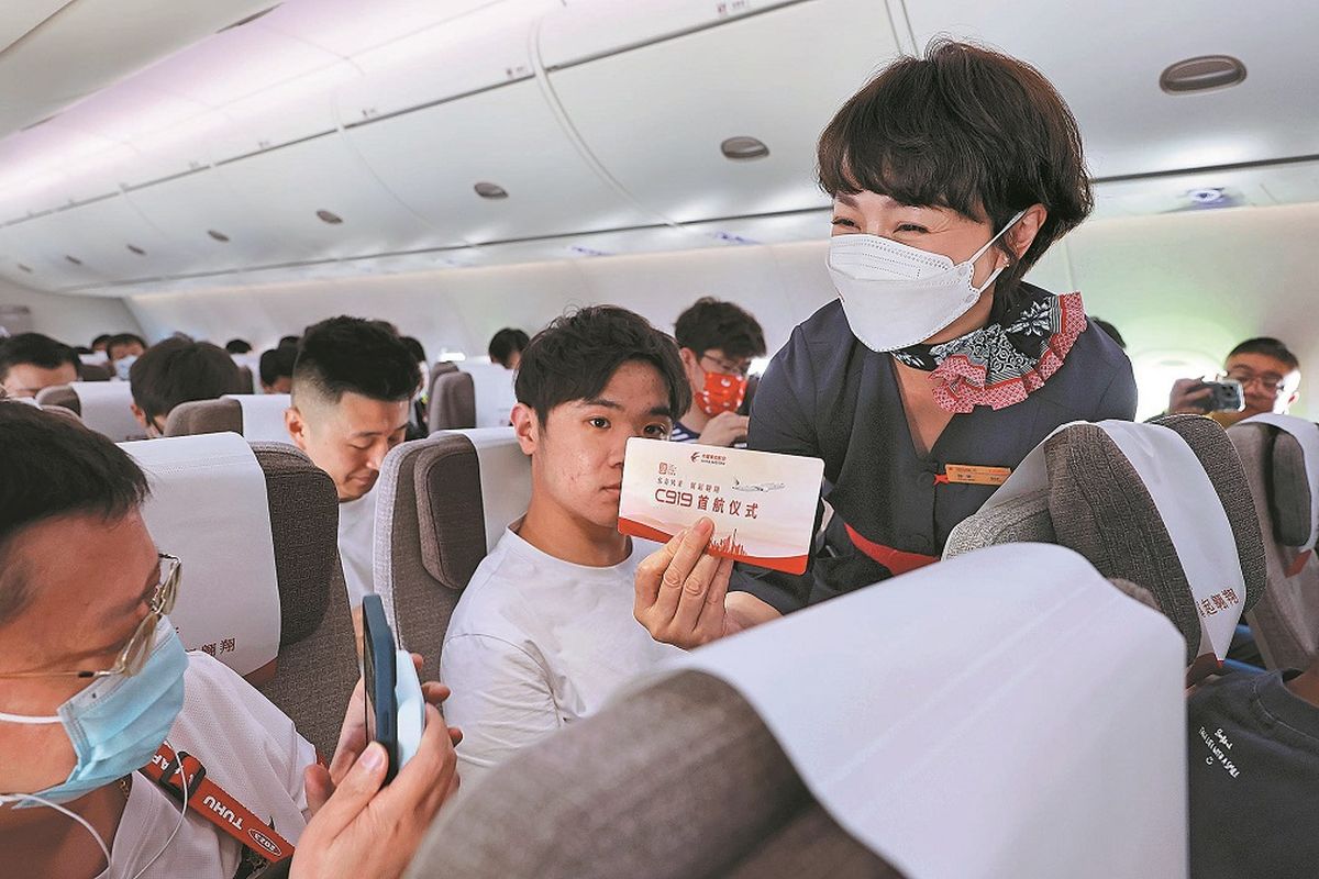 Una azafata de China Eastern Airlines muestra una tarjeta de embarque que indica el primer vuelo del C919. YIN LIQIN / SERVICIO DE NOTICIAS DE CHINA. Una azafata de China Eastern Airlines muestra una tarjeta de embarque que indica el primer vuelo del C919. YIN LIQIN / SERVICIO DE NOTICIAS DE CHINA.