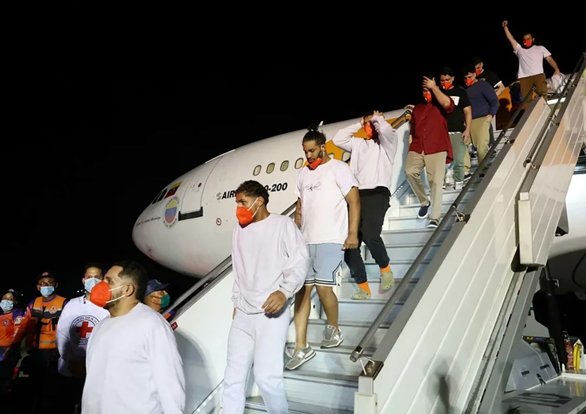 Migrantes bajan de un avión en el Aeropuerto Internacional Simón Bolívar