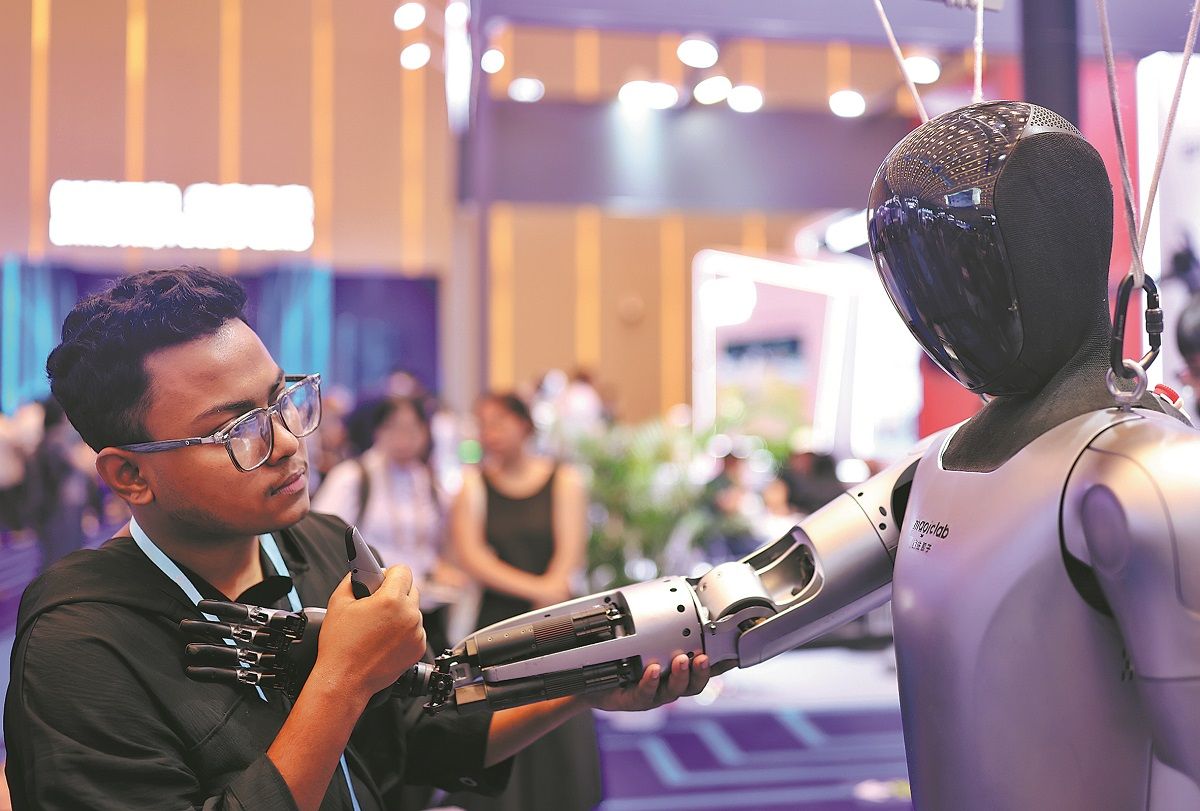 Un visitante interactúa con un robot humanoide durante la 138ª edición de la Feria de Importación y Exportación de China (Feria de Cantón), en Guangzhou, provincia de Guangdong, el 15 de octubre. PARKER ZHENG / CHINA DAILY