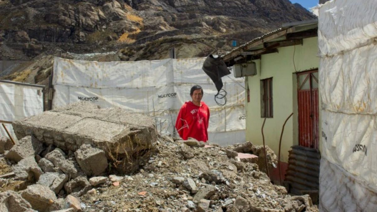 Atachahua se encuentra frente a los escombros de las casas y carreteras demolidas que se amontonan junto a su casa, donde resisti&oacute; durante m&aacute;s de una d&eacute;cada los intentos de trasladarlo a otro lugar. Durante ese tiempo, &eacute;l y las pocas familias que se quedaron tuvieron que depender de paneles solares para iluminar sus hogares y recib&iacute;an agua de forma intermitente (Imagen: Sally Jabiel)