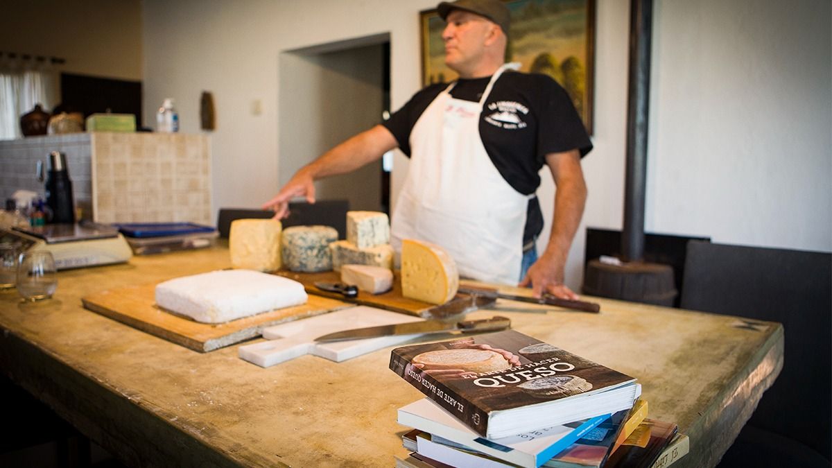 Gustavo Schiavi con sus quesos y sus libros sobre la fabricación de ese producto.