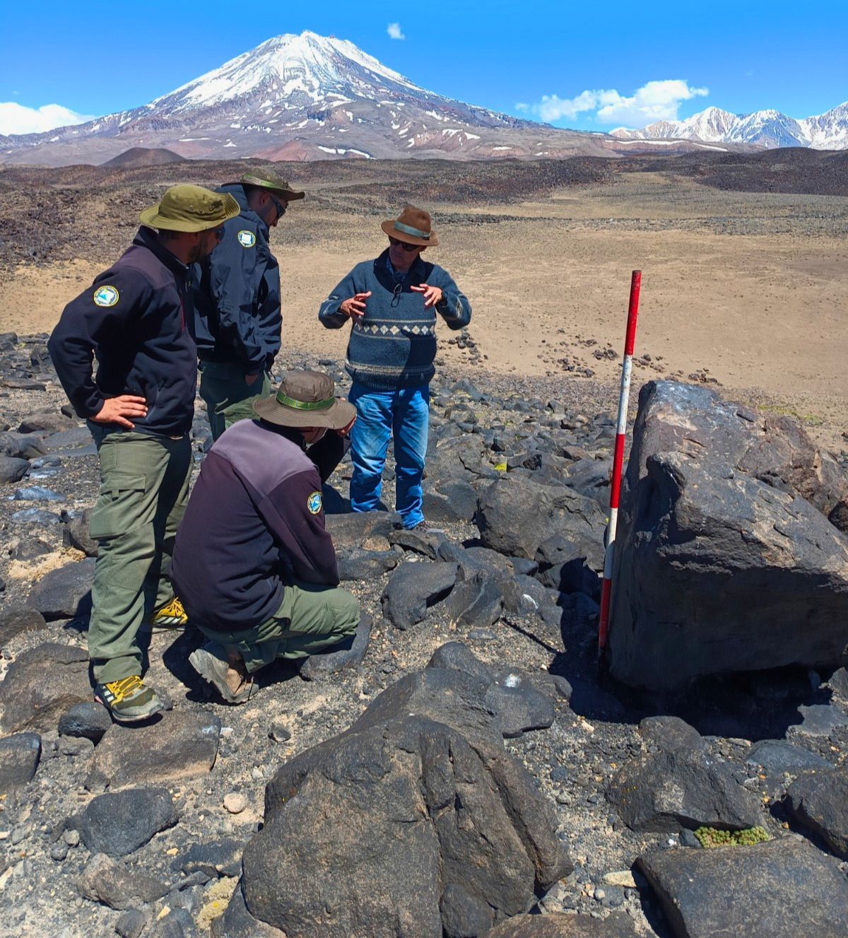 El volcán Maipo de fondo y Víctor Durán dando indicaciones a guardiaparques.