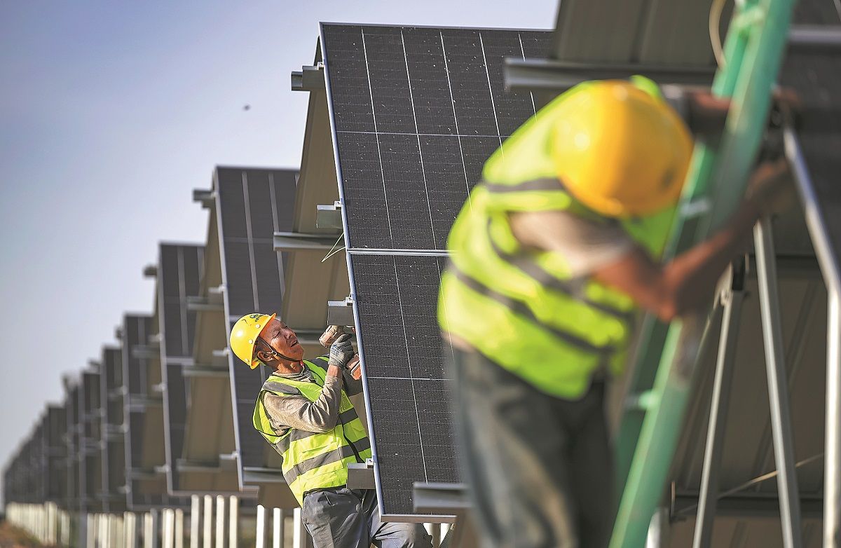 Trabajadores instalan paneles en una planta fotovoltaica en la región autónoma de Mongolia Interior