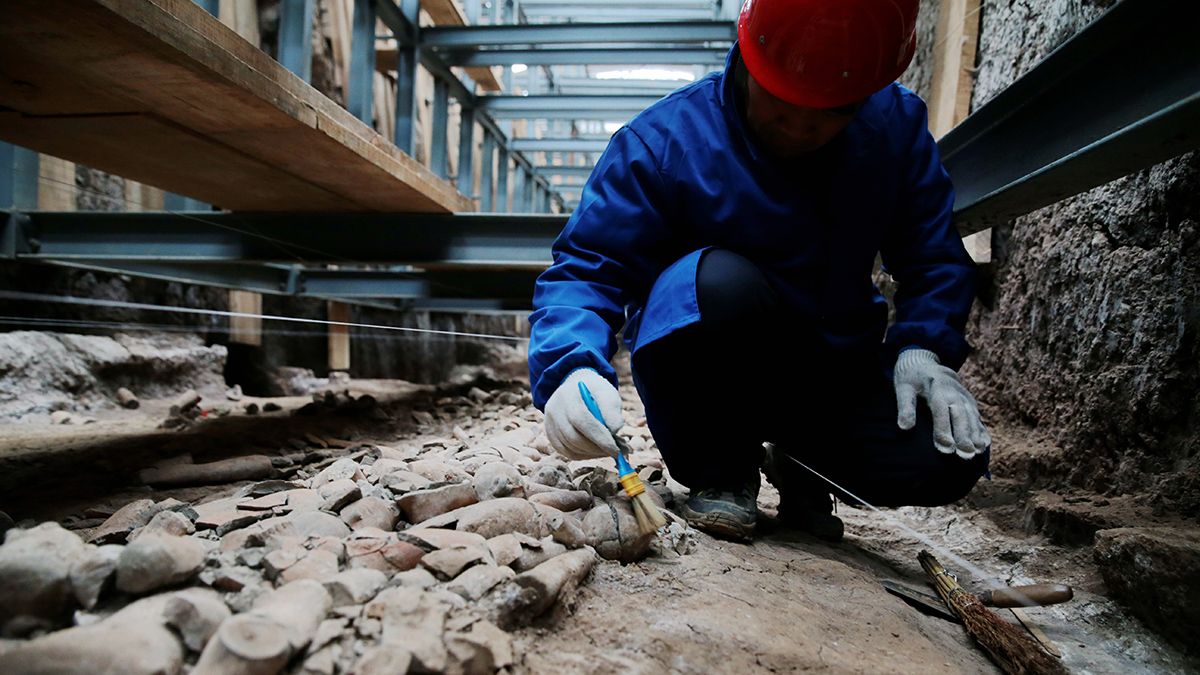 Un arqueólogo limpia los objetos encontrados en la Gran Tumba de Jiangcun en las afueras de Xian