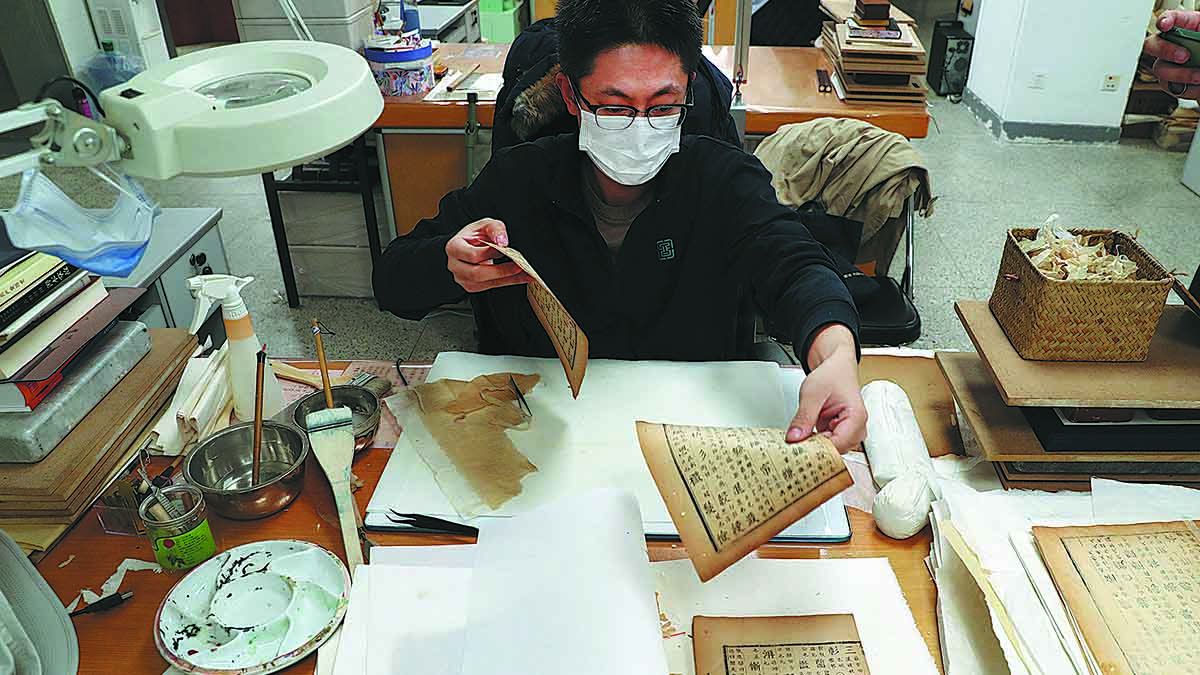 Un técnico restaura un libro antiguo en la Biblioteca Nacional de China en Beijing. ZOU HONG / CHINA DAILY