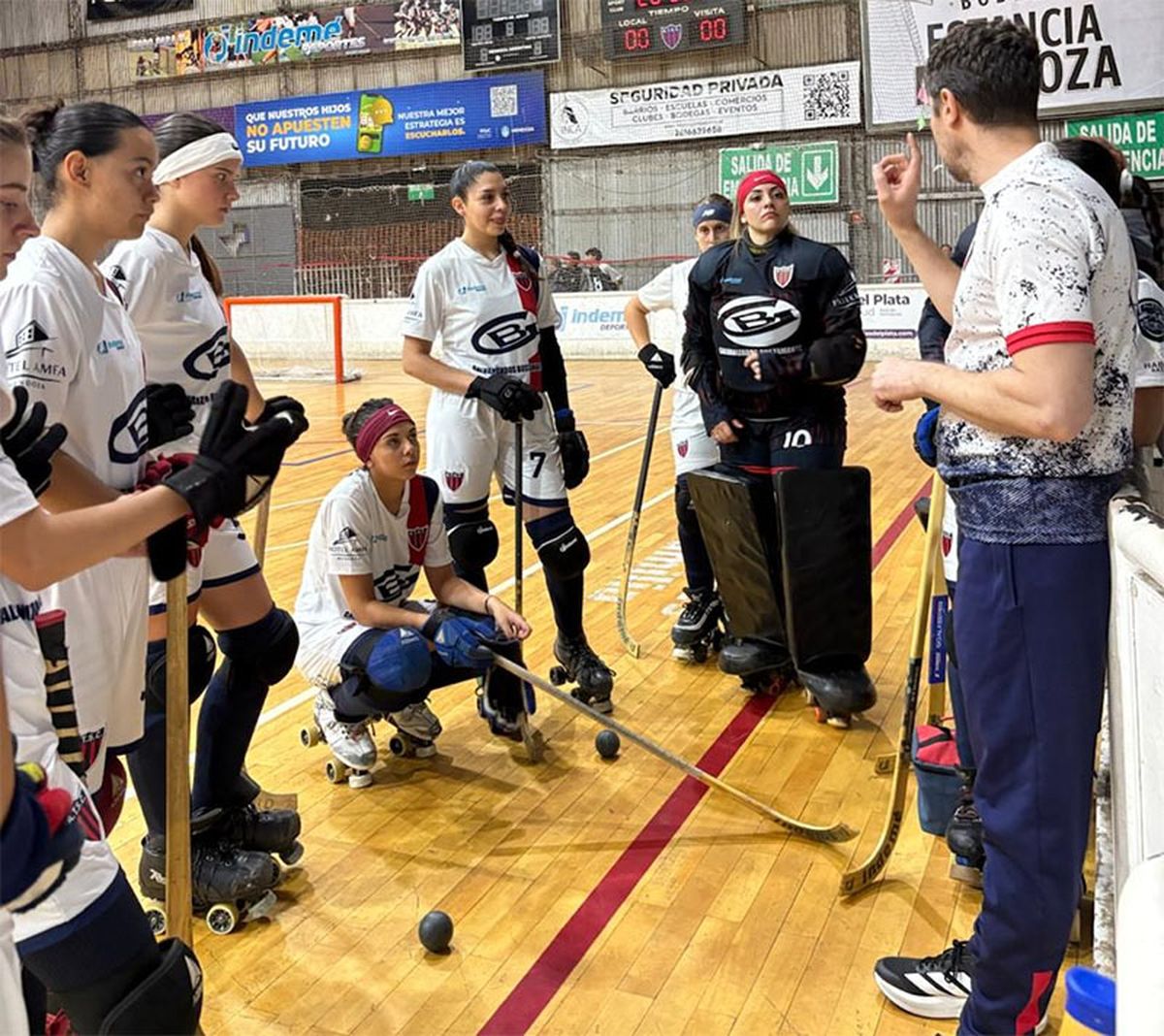 Las chicas de Talleres reciben indicaciones de su entrenador.