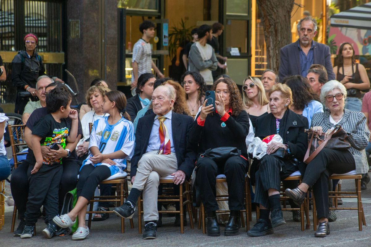 Moisés Roitman (de corbata) durante el reconocimiento de Capital a la farmacia Sevilla donde, a los 100 años, trabaja como cajero. Lo acompañan la hija Claudia (celular en mano) y la esposa, Sara.