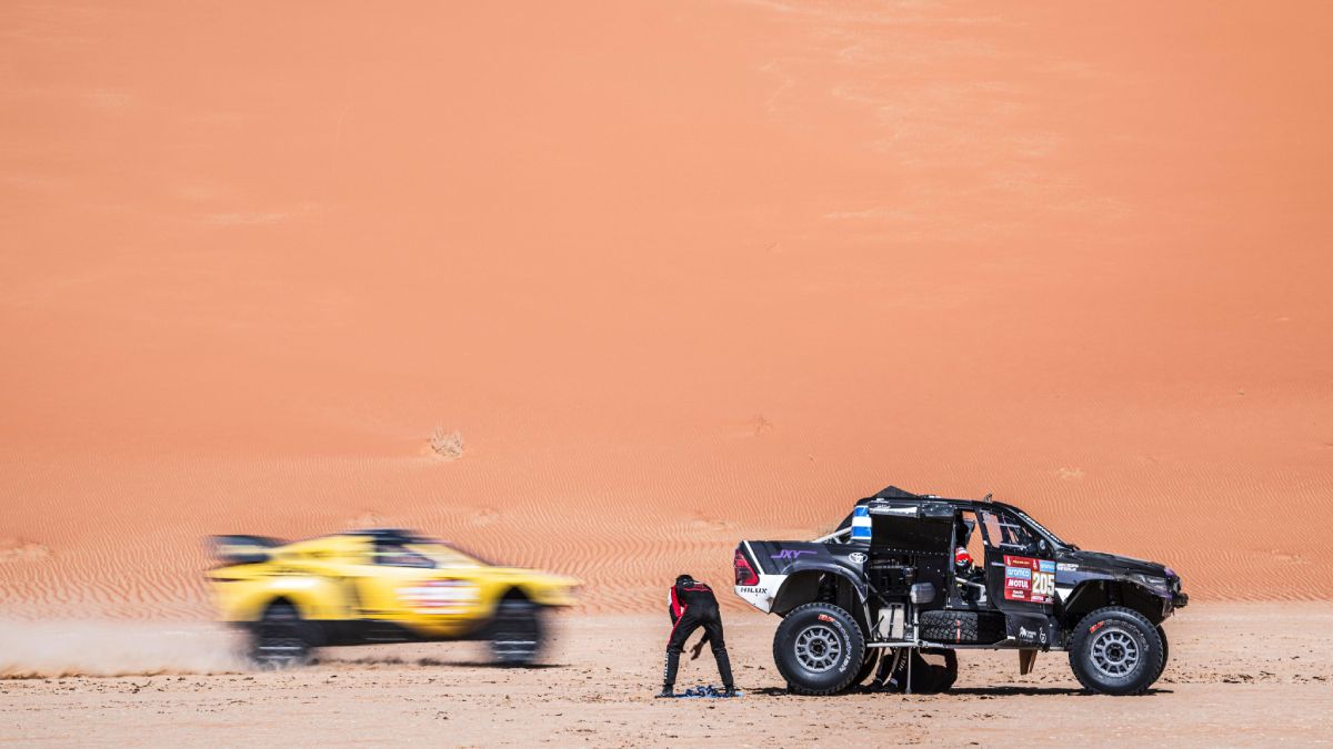 Juan Cruz Yacopini y el español Oliveras miran pasar autos mientras tratan de arreglar la Toyota. Juan Cruz Yacopini y el español Oliveras miran pasar autos mientras tratan de arreglar la Toyota.
