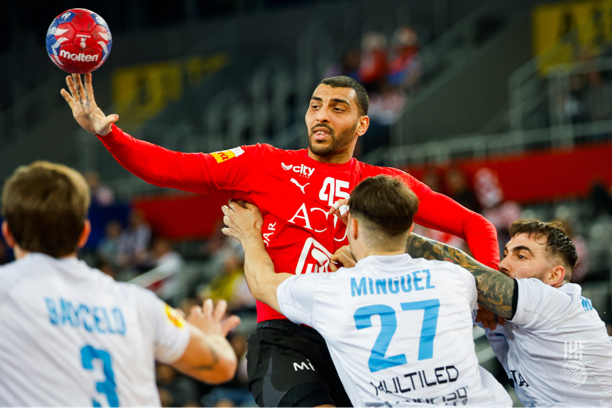 El egipcio Seif Elderaa cede a un compañero ante la triple marca de los defensores de la Selección argentina de handball. El egipcio Seif Elderaa cede a un compañero ante la triple marca de los defensores de la Selección argentina de handball.
