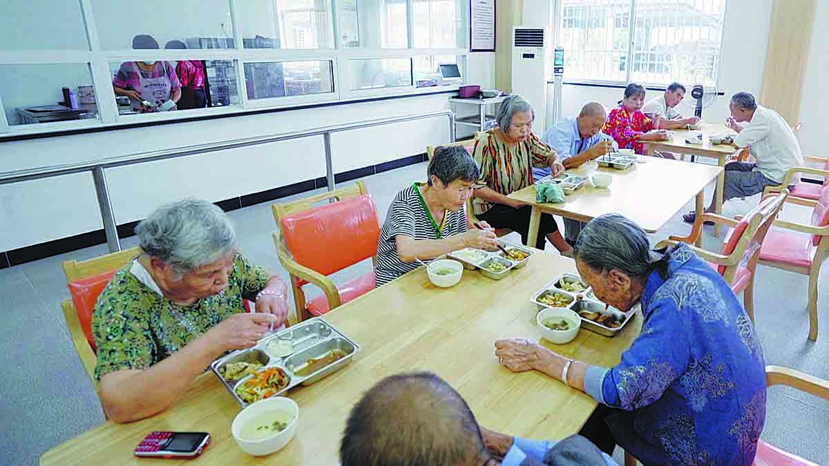 Las personas mayores disfrutan de comidas accesibles en el comedor de un centro público de cuidado de ancianos en Anren