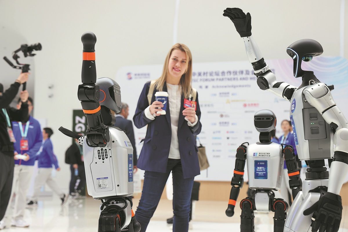 Los robots humanoides atraen la atención de una invitada durante la Conferencia Anual del Foro Zhongguancun 2025 en Beijing el 27 de marzo. WANG JING / CHINA DAILY