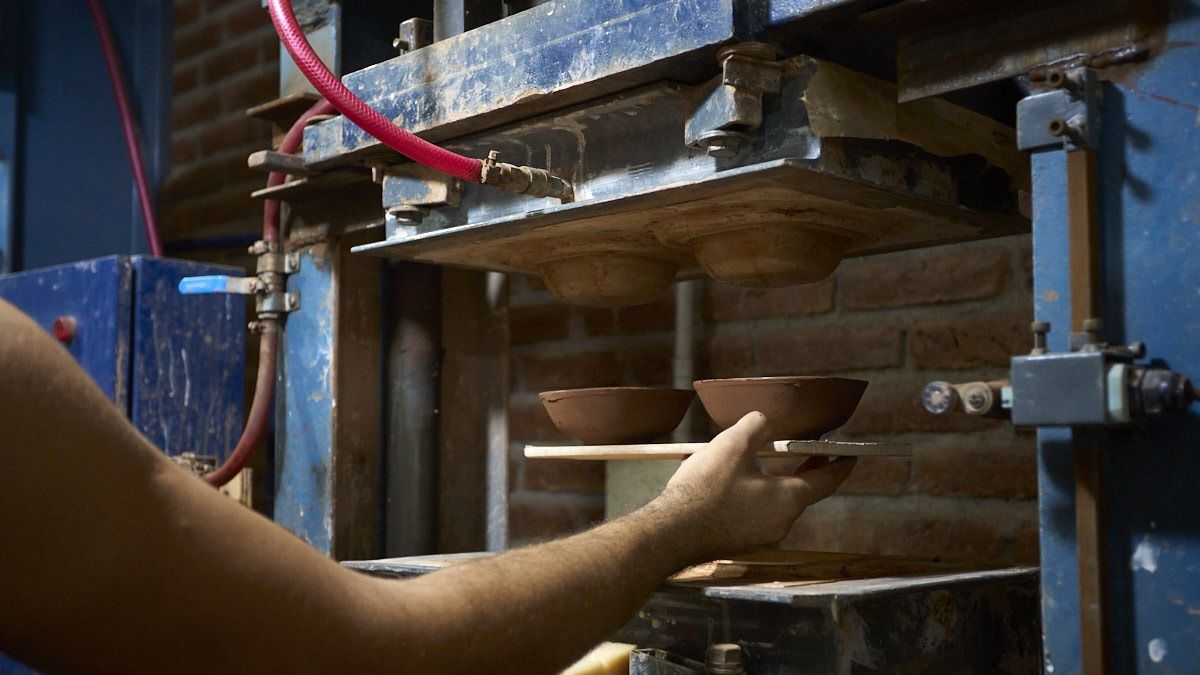 La arcilla se pasa por una máquina que le da la uniformidad y luego por la prensa. La arcilla se pasa por una máquina que le da la uniformidad y luego por la prensa.