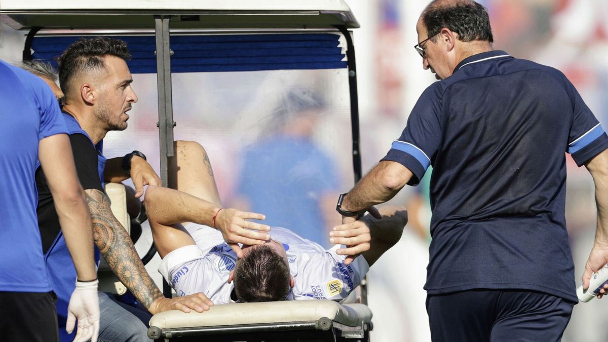 El defensor de Godoy Cruz Gianluca Ferrari se retira en camilla tras la lesión en la rodilla derecha.
