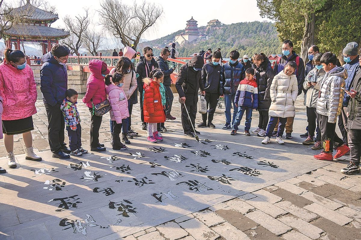 Un hombre escribe en el suelo y atrae a una multitud en el Palacio de Verano en Beijing. WANG BAOSHENG/ PARA CHINA DAILY Un hombre escribe en el suelo y atrae a una multitud en el Palacio de Verano en Beijing. WANG BAOSHENG/ PARA CHINA DAILY