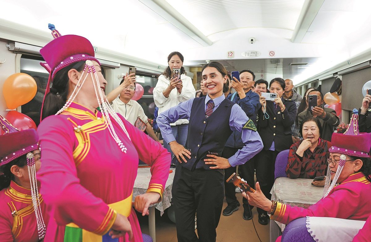 Una conductora tayika baila para los pasajeros junto con artistas folclóricas en el tren que sale de la prefectura de Kashgar, región autónoma uygur de Xinjiang, hacia la ciudad de Chengdu, provincia de Sichuan. HU HUHU / XINHUA