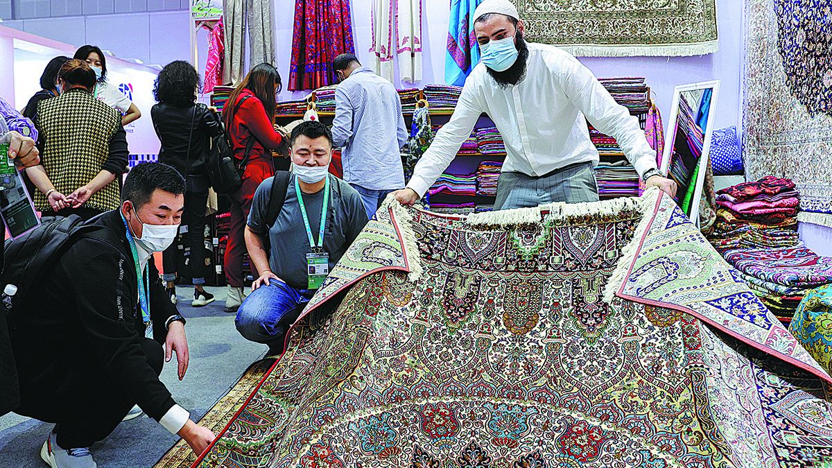 Un expositor extranjero (derecha) mostró una manta hecha a mano a los compradores