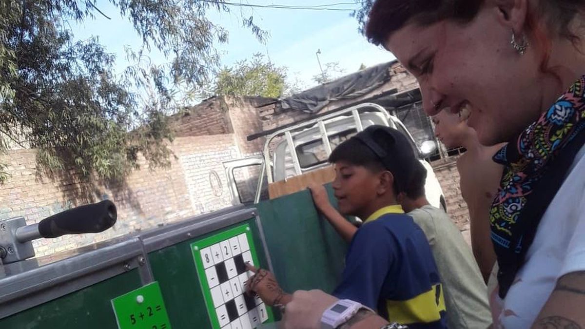 Martina Di Pasquale, coordinadora del proyecto de la escuela móvil, junto a uno de los niños del barrio Castro. Martina Di Pasquale, coordinadora del proyecto de la escuela móvil, junto a uno de los niños del barrio Castro.