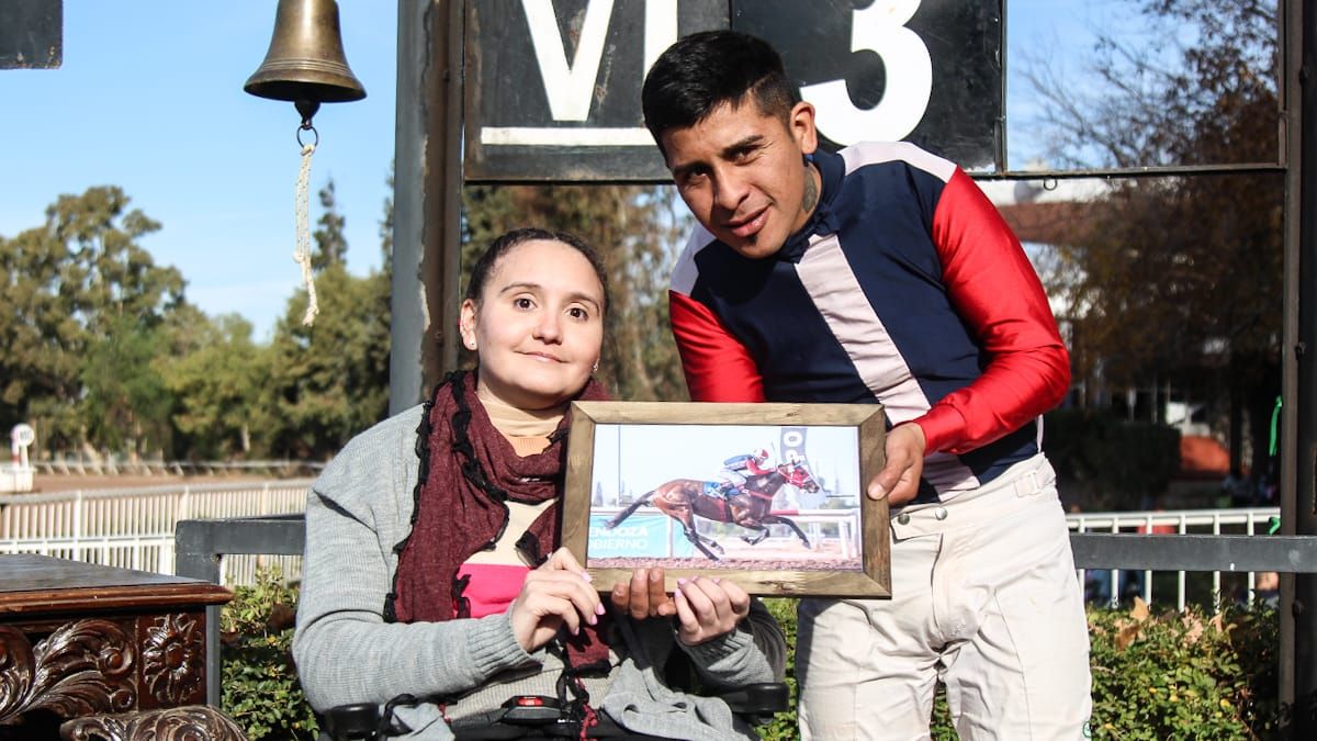 Florencia Giménez le entrega su premio al jockey ganador Facundo Campos. Fue por la 7ª carrera de este domingo en Hipódromo de Mendoza, prueba que llevó el nombre de la jocketa accidentada el año pasado.