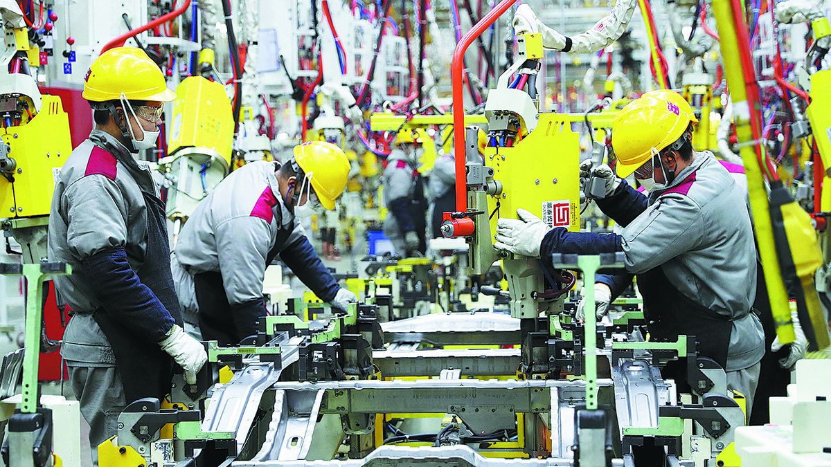 Los empleados de Beijing Automobile Works Co trabajan en una línea de ensamblaje en una fábrica de la sede de la compañía en Qingdao