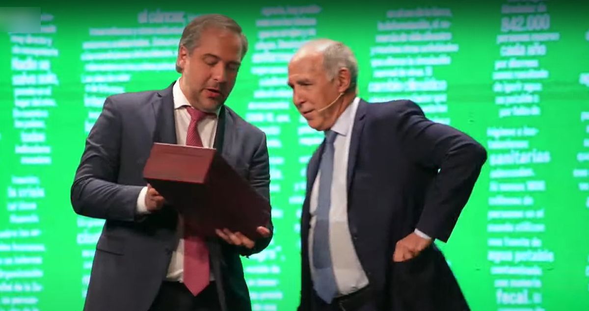 Matías Stevanato entregando un regalo a Ricardo Lorenzetti cuando el miembro de la Corte Suprema de Justicia terminó su conferencia.